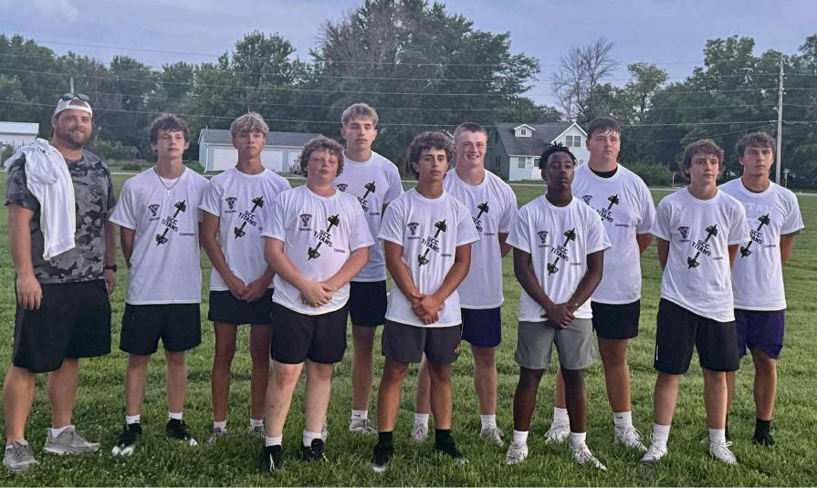 Team members stand on the field, wearing matching SCC Titans T-shirts and black shorts.